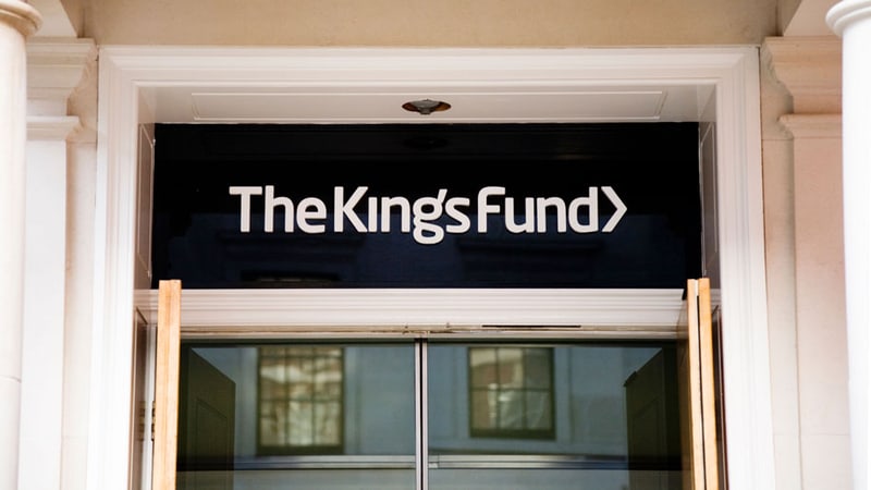The entrance to The King's Fund's offices, the charity's name lettered above glass doors set between stone columns.